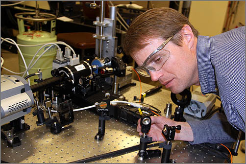 NREL Senior Scientist Brian Flugel adjusts mirrors to set up an experiment aimed at testing the quality of a green LED. Credit: Bill Scanlon.